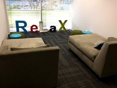 a living room with couches and chairs in front of a window that reads relax