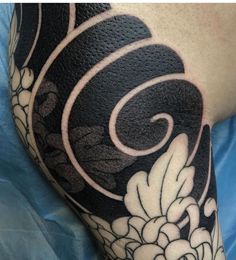 a black and white tattoo with flowers on the side of a man's arm