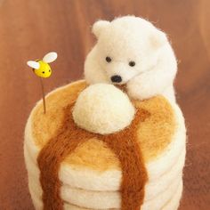 there is a small stuffed bear sitting on top of a stack of crepe