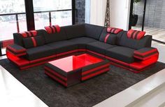 a black and red sectional sofa sitting on top of a rug