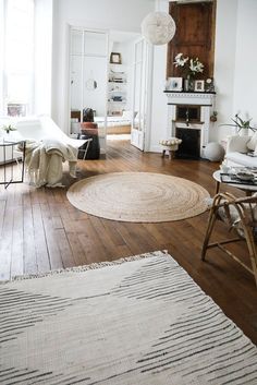 a living room filled with furniture and a rug on top of a hard wood floor