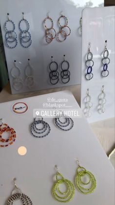 several pairs of earrings are on display in a store window, with the price tag below them