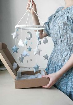 a woman holding a box with stars hanging from it