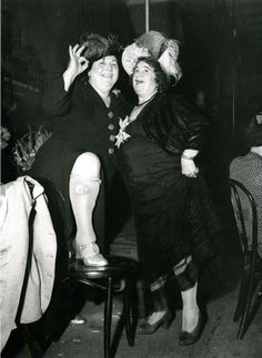 two women standing next to each other in black and white