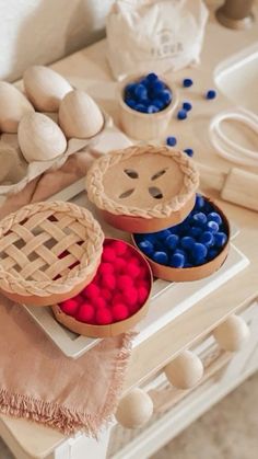 three pies with red, white and blue toppings on a table next to doughnut holes