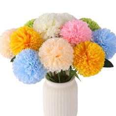 a white vase filled with lots of colorful flowers