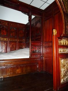 a bed in a room with wooden paneling and walls on either side of it