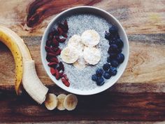 a bowl of oatmeal with bananas, blueberries, and other fruits