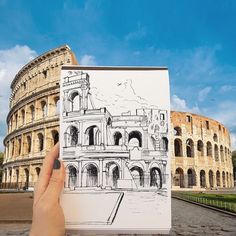 a hand holding up a drawing in front of the colossion, rome italy