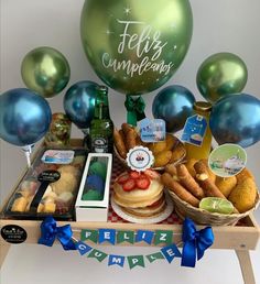 a table topped with lots of food and balloons