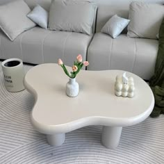 a white coffee table with flowers in a vase