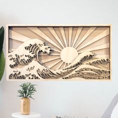 a wooden cutout of a wave in the ocean on a wall next to a potted plant