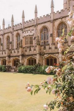 an old building with many windows and flowers in the foreground