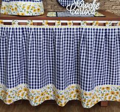 a blue and white gingham table cloth with sunflowers on the border