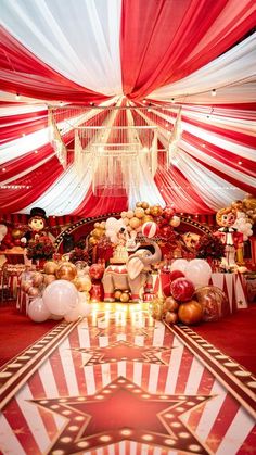 a large red and white tent with stuffed animals on it's sides, decorated for a circus themed birthday party