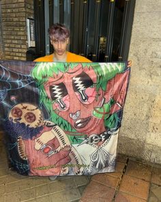 a young man holding up a large poster