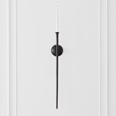 a white door with a black handle and a candle in the middle on it's side