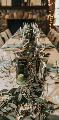 a long table is set with wine glasses and place settings for the guests to enjoy