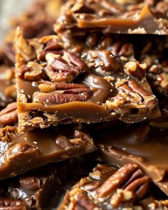 there are many pieces of chocolate and pecans on top of each other with nuts