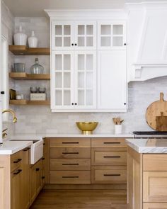 a kitchen with white cabinets and wooden floors