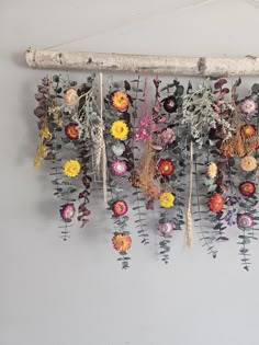 an arrangement of flowers hanging on a wall