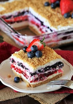 a piece of cake on a plate with strawberries and blueberries in the middle