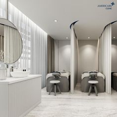 the interior of a modern bathroom with white fixtures and marble flooring, along with two circular mirrors