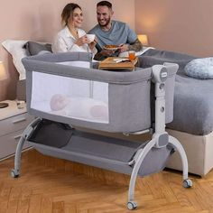 a man and woman are sitting in a baby crib