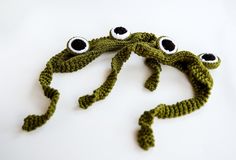 a crocheted green frog with eyes on it's head is shown in front of a white background