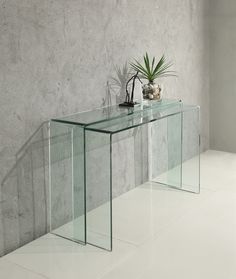 a glass console table with two plants on top