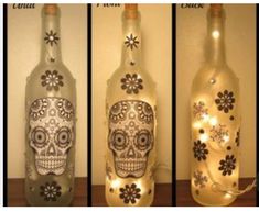 three bottles that have lights in them and decorated with sugar skulls on the inside one