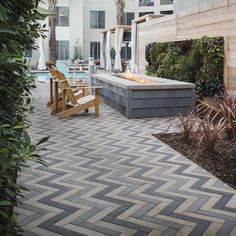 an outdoor hot tub surrounded by trees and plants next to a swimming pool with lounge chairs