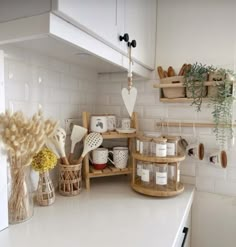 a kitchen with white counter tops and shelves filled with pots, pans and other items