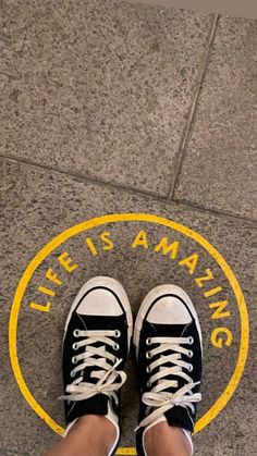 a person standing in front of a yellow and white sign that says life is amazing