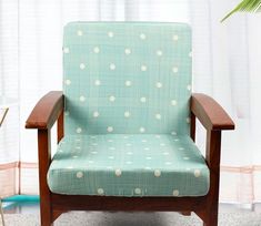 a blue chair with white polka dots on it in front of a table and potted plant