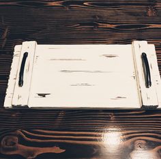 a wooden table topped with a white tray and two black pen holders on top of it