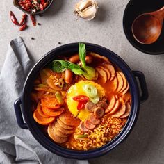 a bowl filled with meat and vegetables next to other foods on top of a table