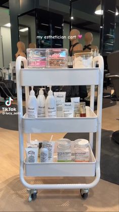 a white cart filled with lots of different types of skin care products on top of a wooden floor