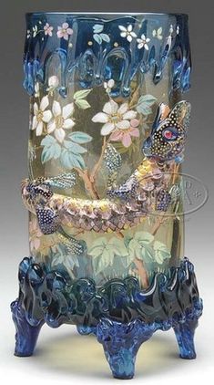 a glass vase sitting on top of a wooden stand with flowers and butterflies painted on it