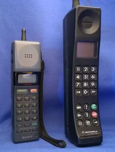 an old cell phone is next to a new one on a blue background with the cord still attached