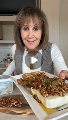 a woman sitting at a table in front of a white plate with food on it