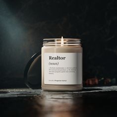 a candle is sitting on a table with the words realtor written in front of it