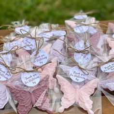 some pink and purple butterflies are on display in plastic bags with tags that say i love you