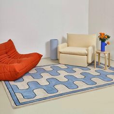 a living room with two chairs and a rug