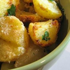 a green bowl filled with fried potatoes and parsley