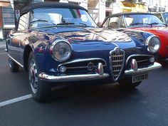 two classic cars parked next to each other in a parking lot