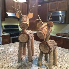 two wooden reindeer statues sitting on top of a kitchen counter