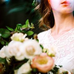 a woman holding a bouquet of flowers in front of her face