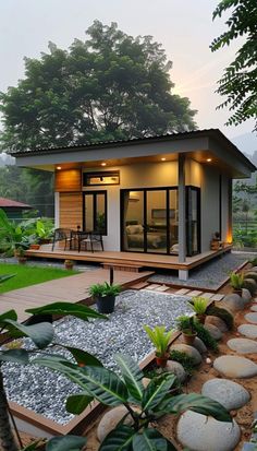 the small house is surrounded by plants and rocks