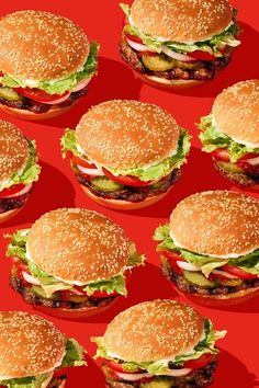 many hamburgers with lettuce and tomatoes on them are arranged in a pattern